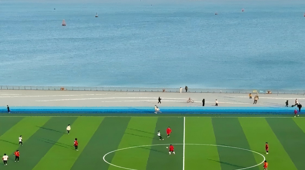 A dream setting：Green football field by blue sea